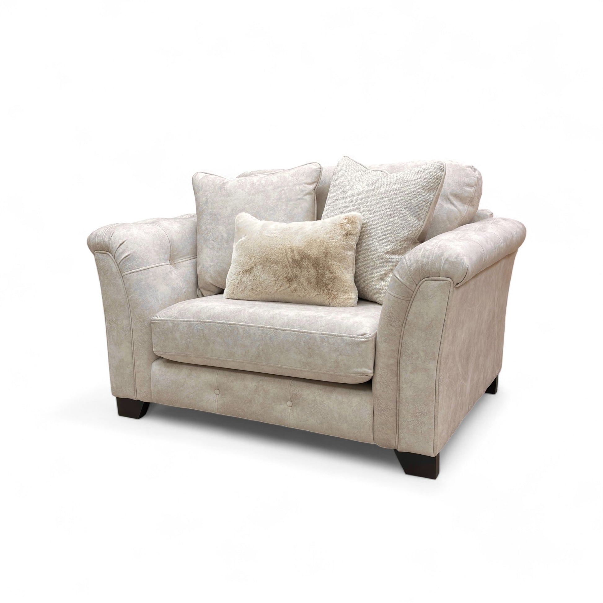 Beige fabric snuggler armchair with rolled arms and accent pillows.