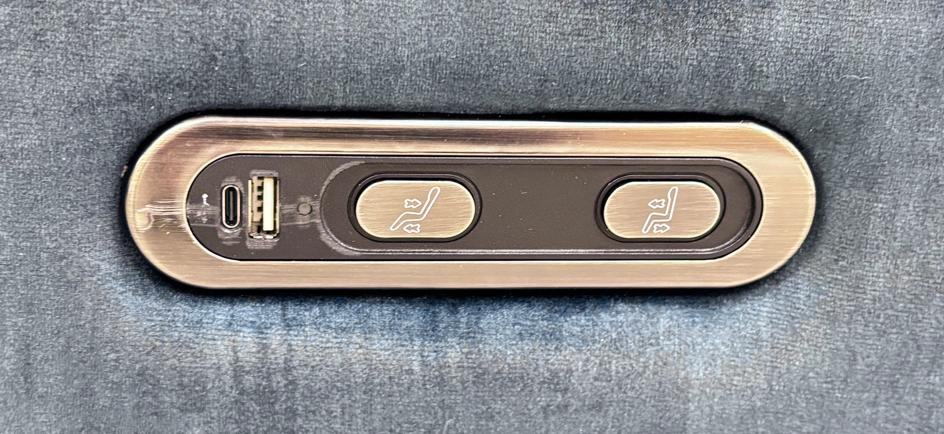 Close-up of the built-in power recliner control panel on the side of the Sloane Heritage sofa, featuring metallic buttons.