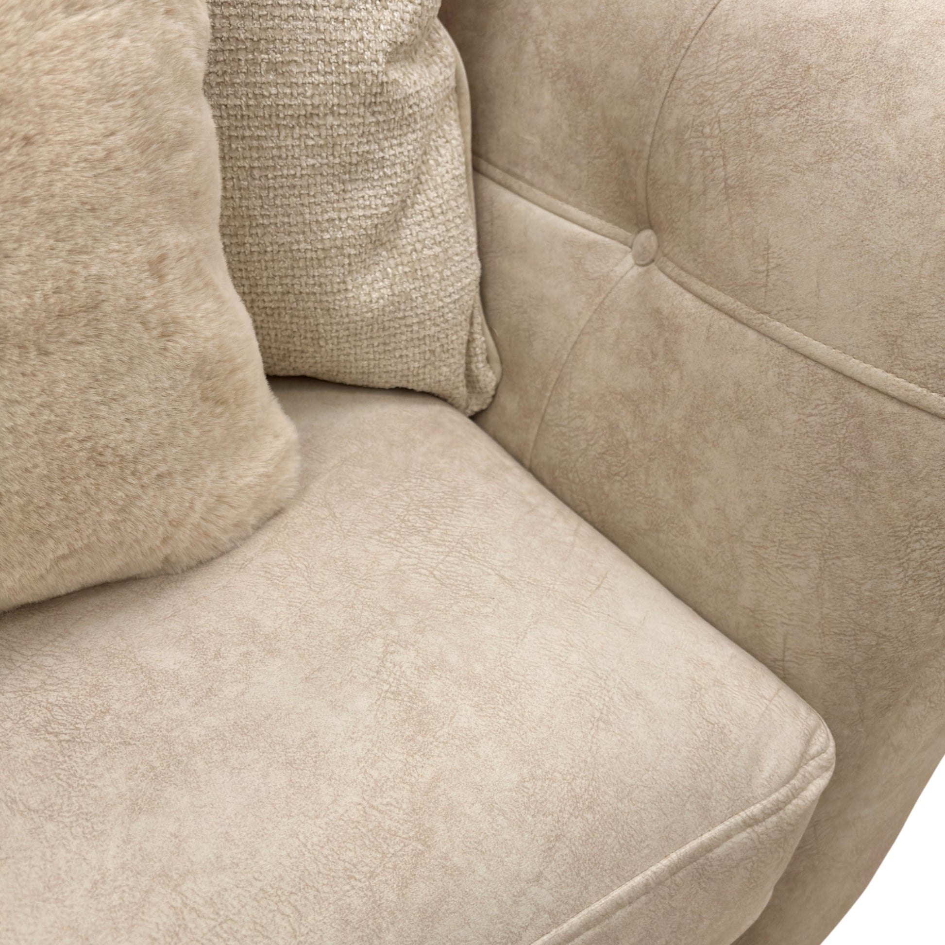 Beige fabric snuggler armchair with rolled arms and accent pillows.