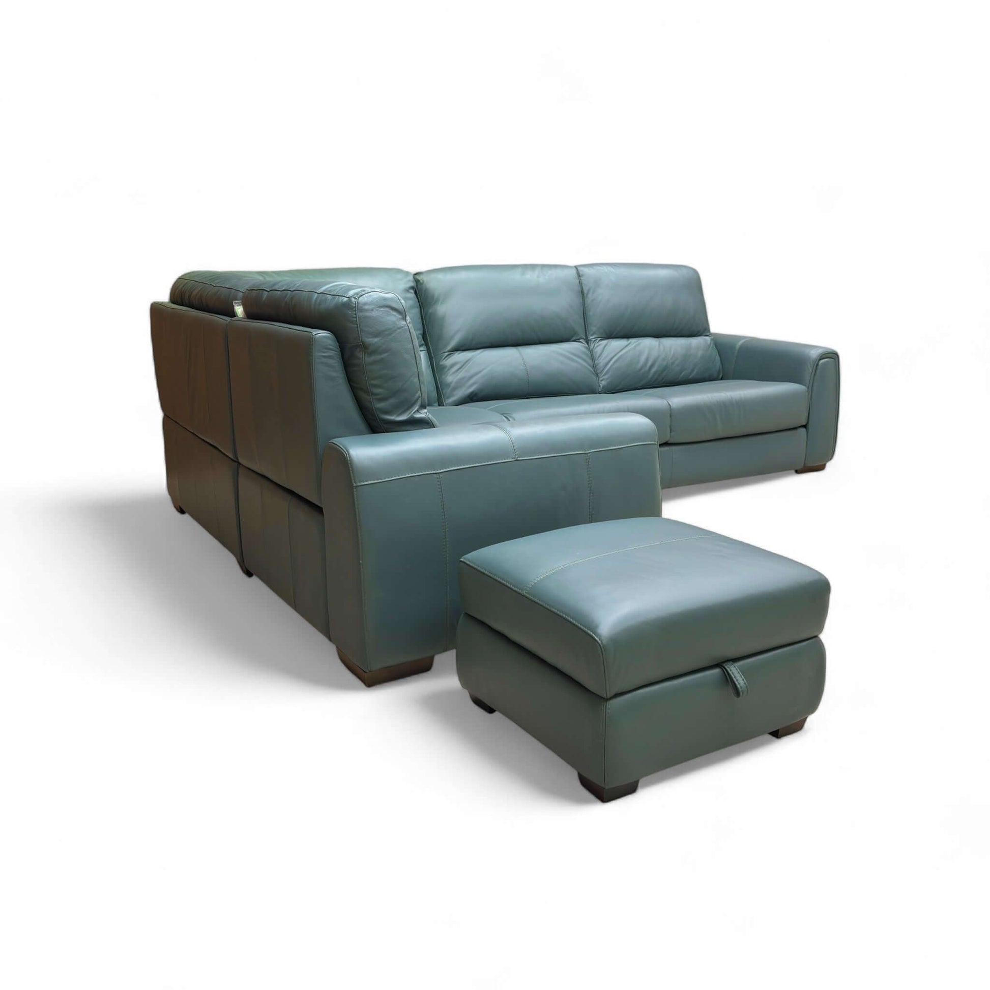 Teal leather sectional sofa with ottoman on a white background