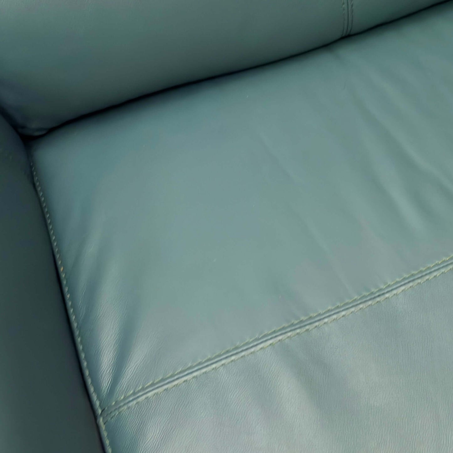 Close-up of a Green leather sofa with stitching detail