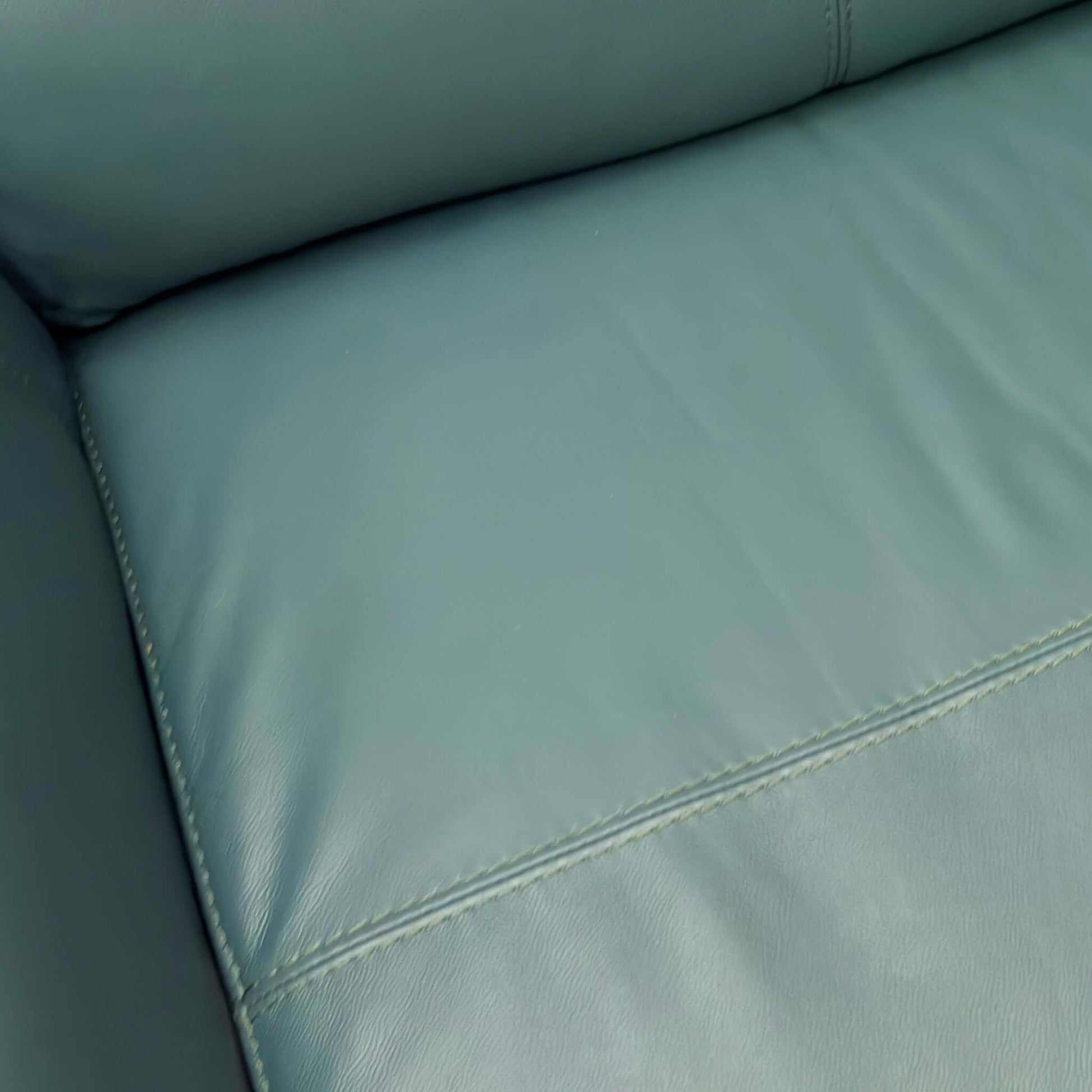 Close-up of a Green leather sofa with stitching detail