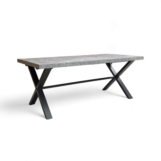 Dining table with concrete top and black metal legs on a white background