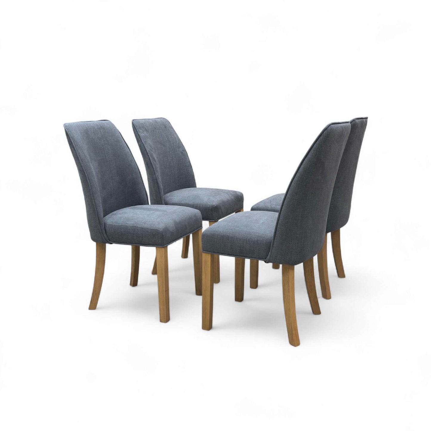 Four gray upholstered chairs with wooden legs on a white background