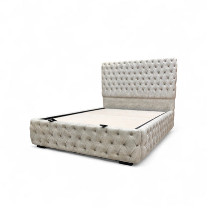 Side profile view of the Belford velvet bed, showing the full height of the floor-standing headboard and the streamlined base.