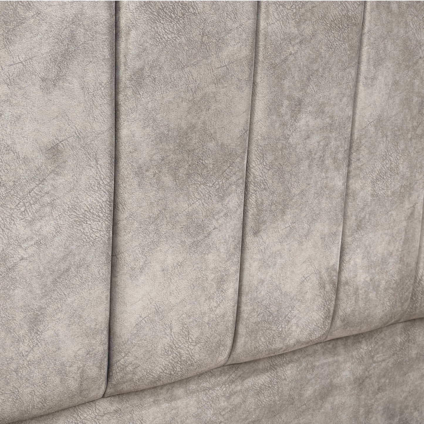 Close-up of a textured gray fabric surface of a bed with storage