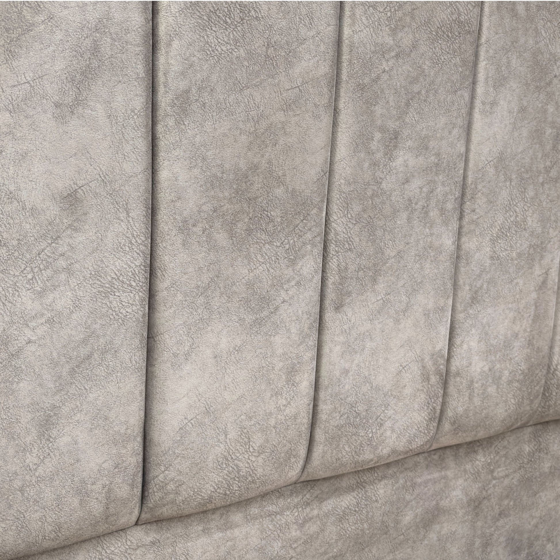 Close-up of a textured gray fabric surface of a bed with storage