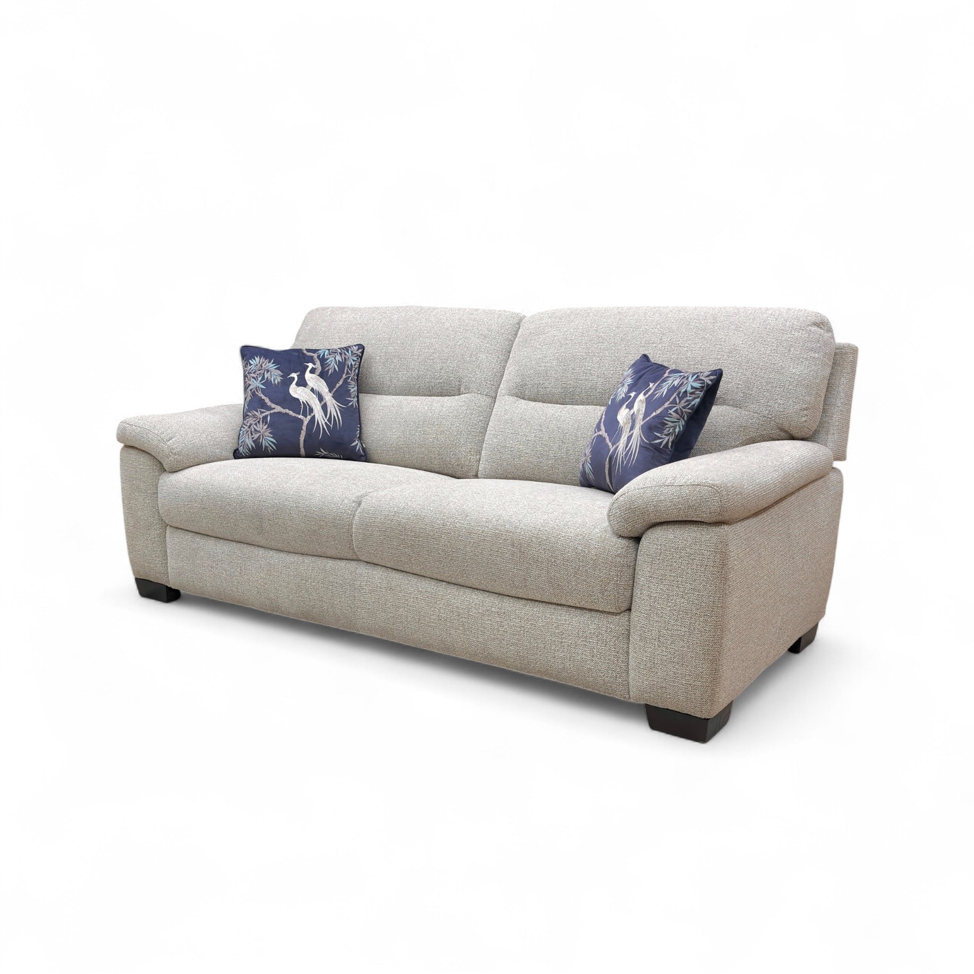 Beige sofa with two blue pillows on a white background