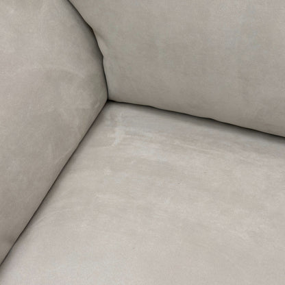 Close-up detail of the padded armrest and the luxurious texture of the Silver Suede fabric on the sofa.