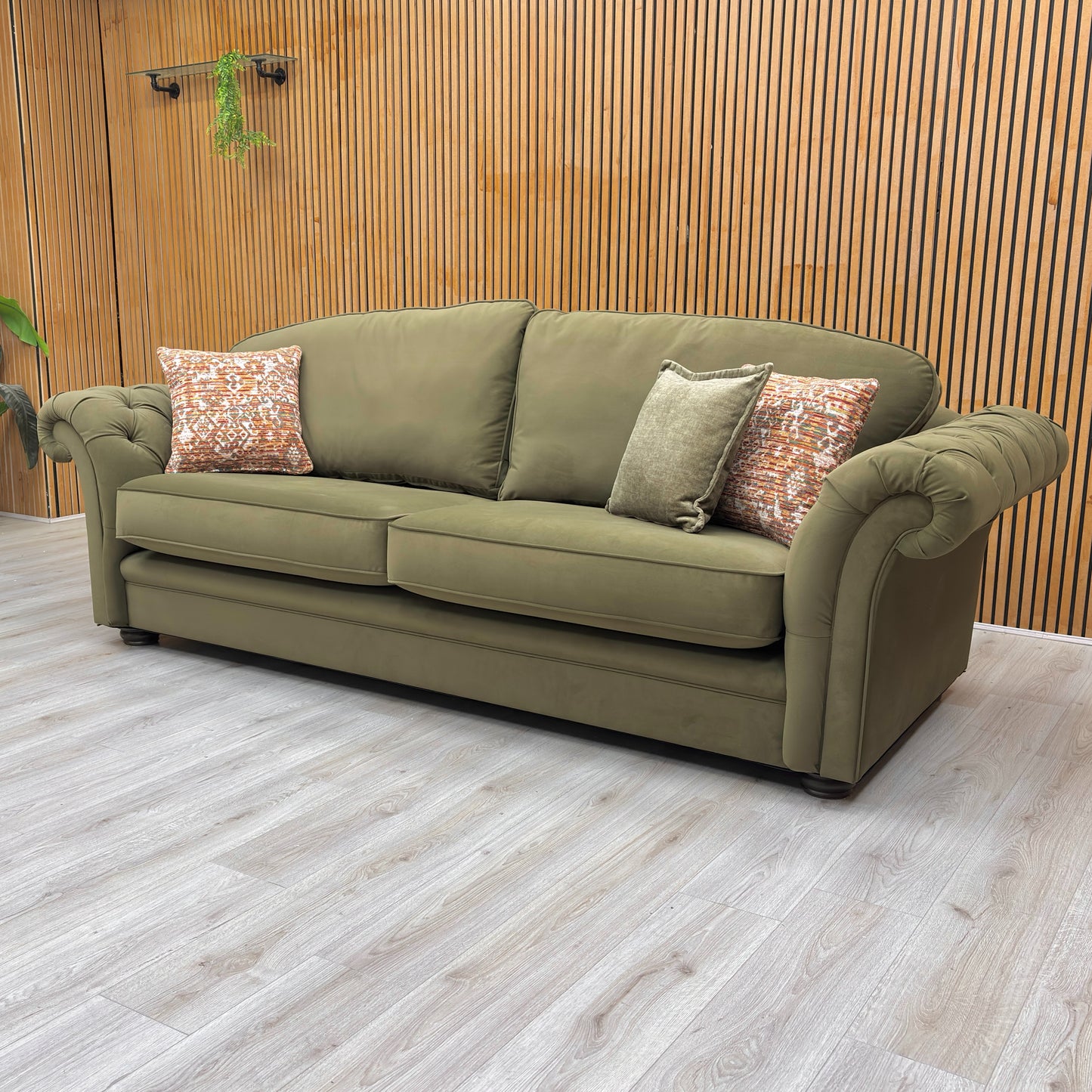 lifestyle image of the ‘Vincent’ olive green velvet sofa in a modern, stylish lounge setting.