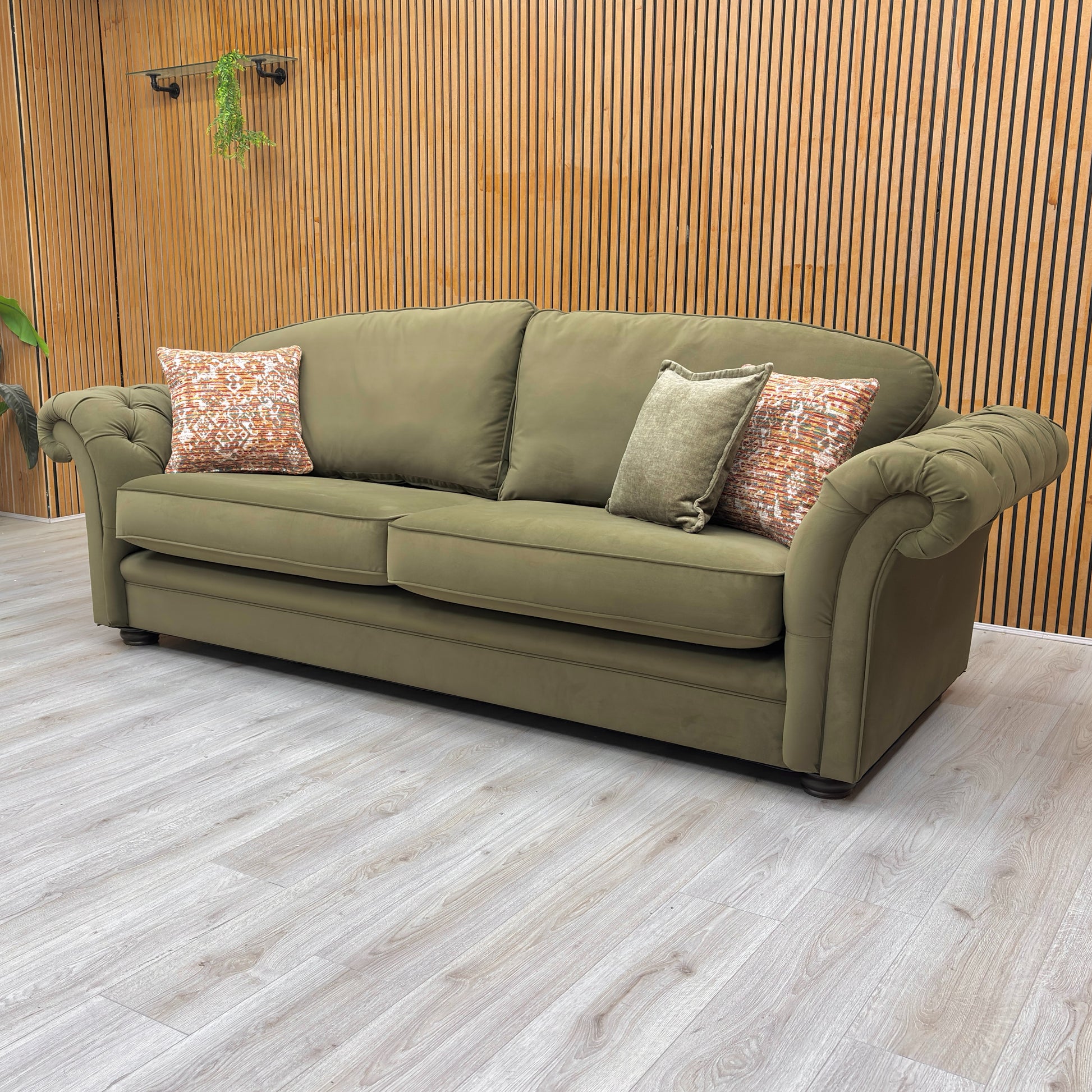 lifestyle image of the ‘Vincent’ olive green velvet sofa in a modern, stylish lounge setting.