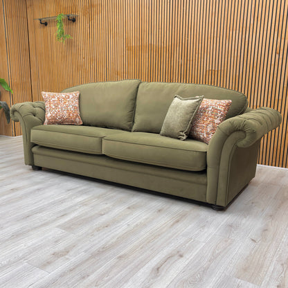 lifestyle image of the ‘Vincent’ olive green velvet sofa in a modern, stylish lounge setting.