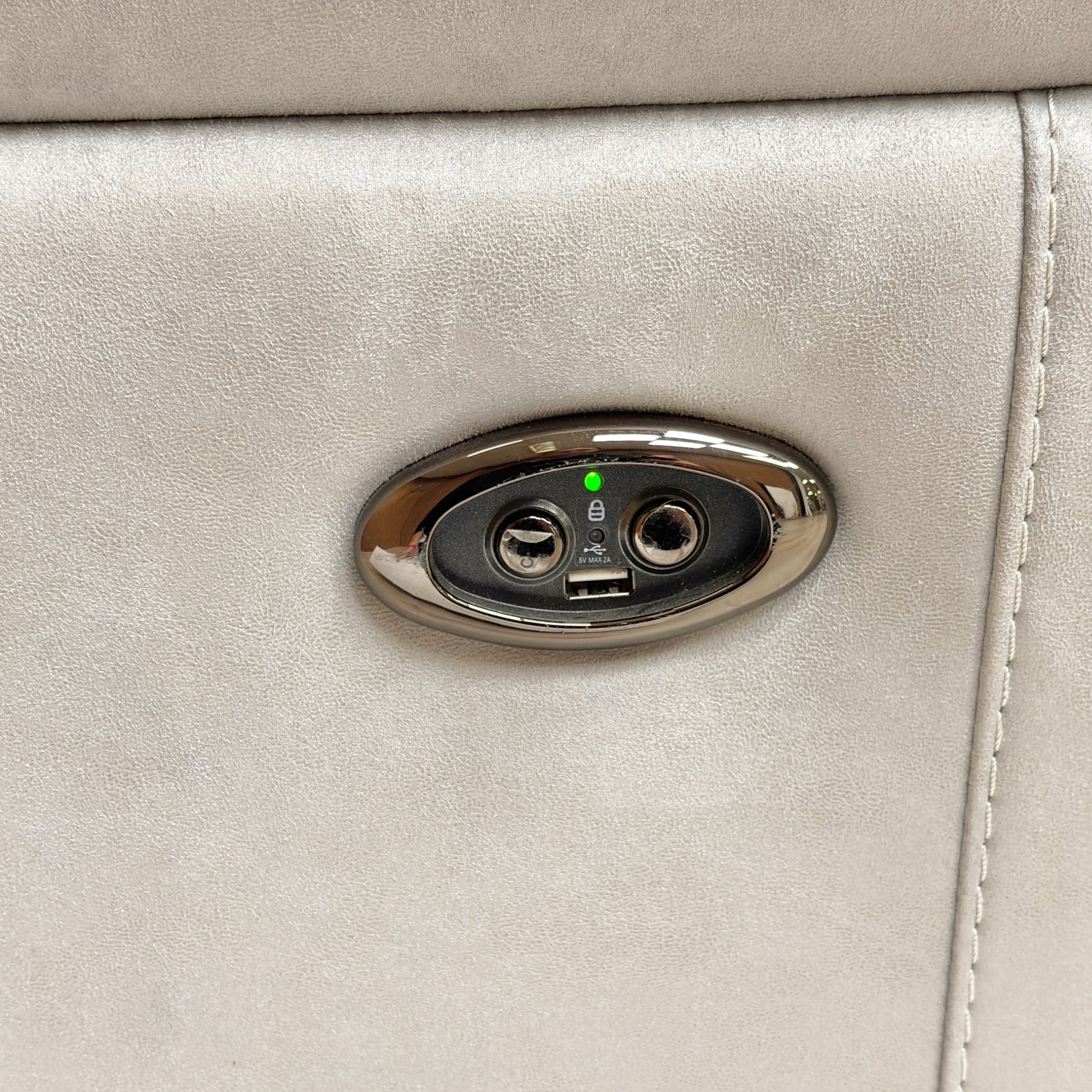 Close-up of the power recliner control buttons embedded on the inner side of the armrest.