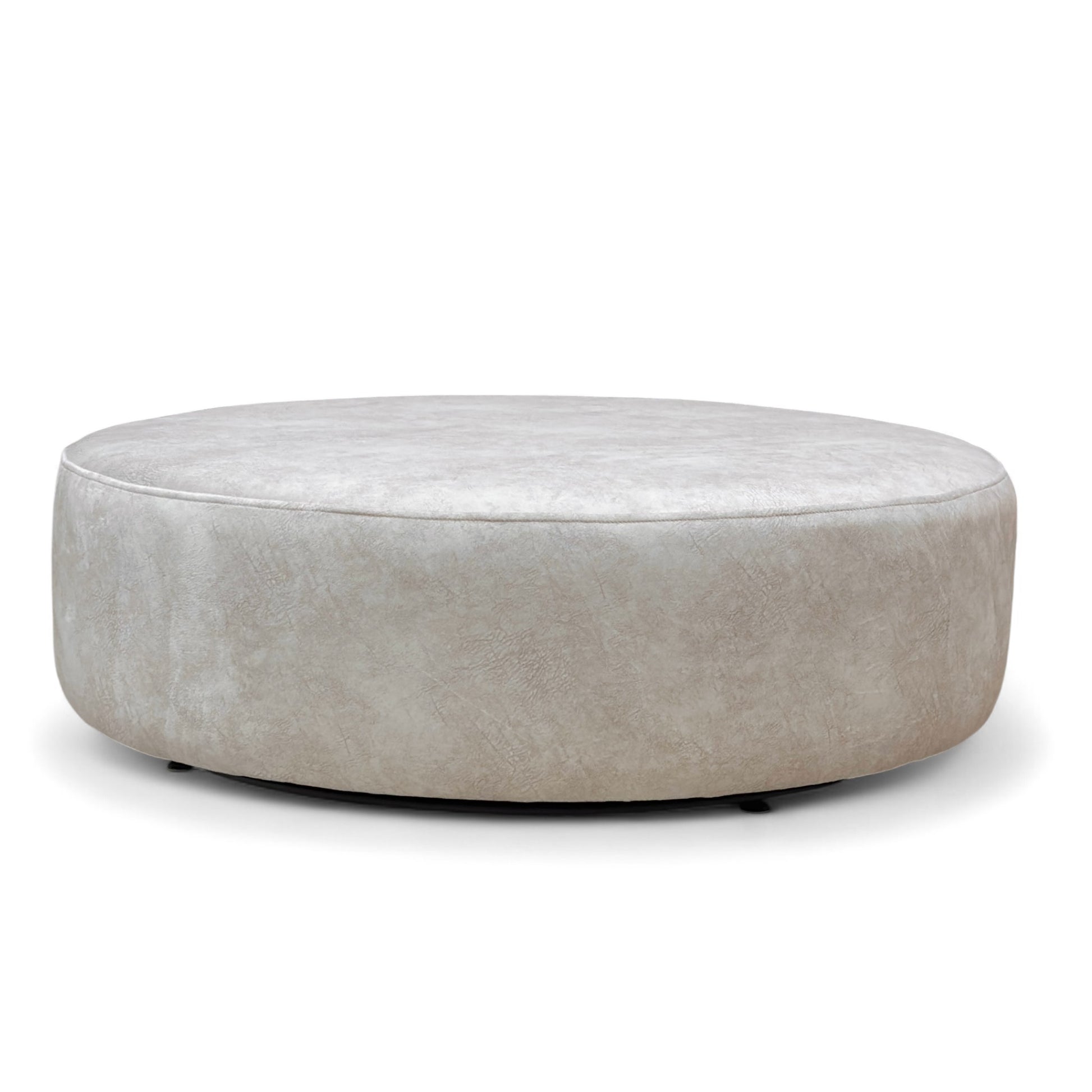 Full view of the large, circular 'Mariah' Twister Footstool, upholstered in Dapple Cream Velvet with a contrasting patterned top cushion