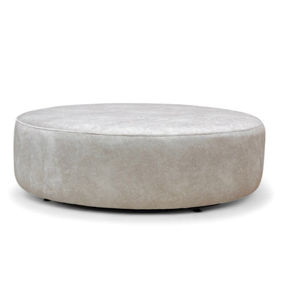Full view of the large, circular 'Mariah' Twister Footstool, upholstered in Dapple Cream Velvet with a contrasting patterned top cushion