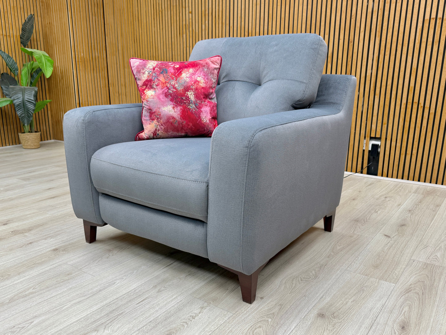 Side view of the 'Iris' steel grey velvet power recliner armchair in the standard, upright seating position.