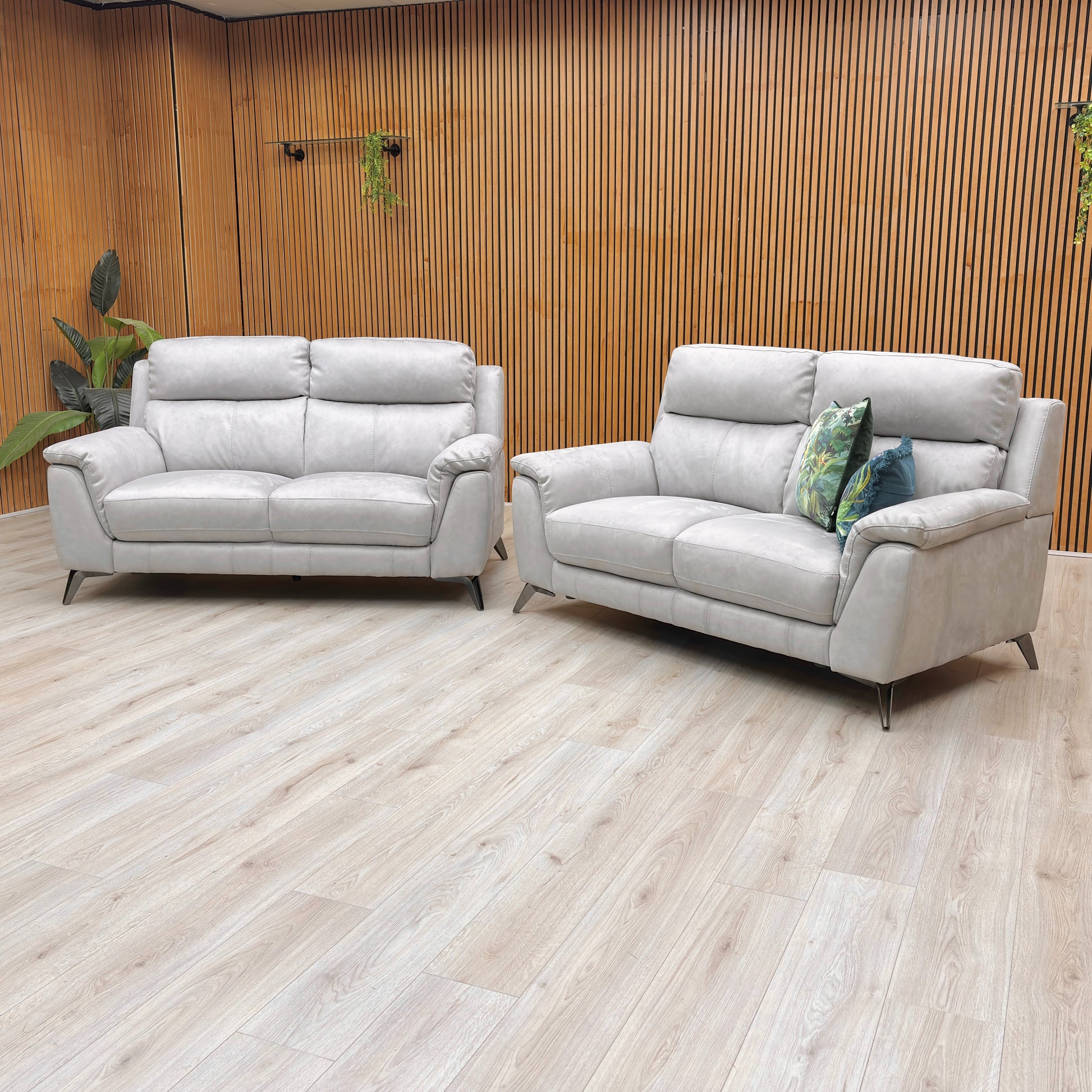 Side and back profile view of the Contempo sofa, emphasizing the open base design and modern metal legs, placed in a properly lit, modern room with wooden flooring.