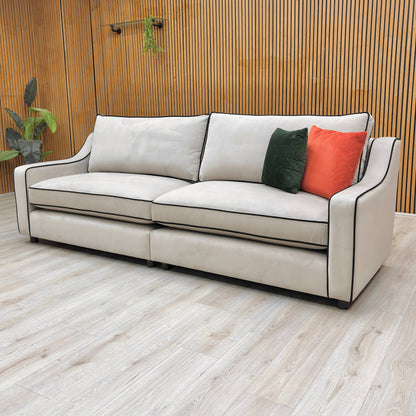 the plush platinum velvet fabric upholstery, showing the soft, reflective quality of the material and the sofa's stitch detailing.