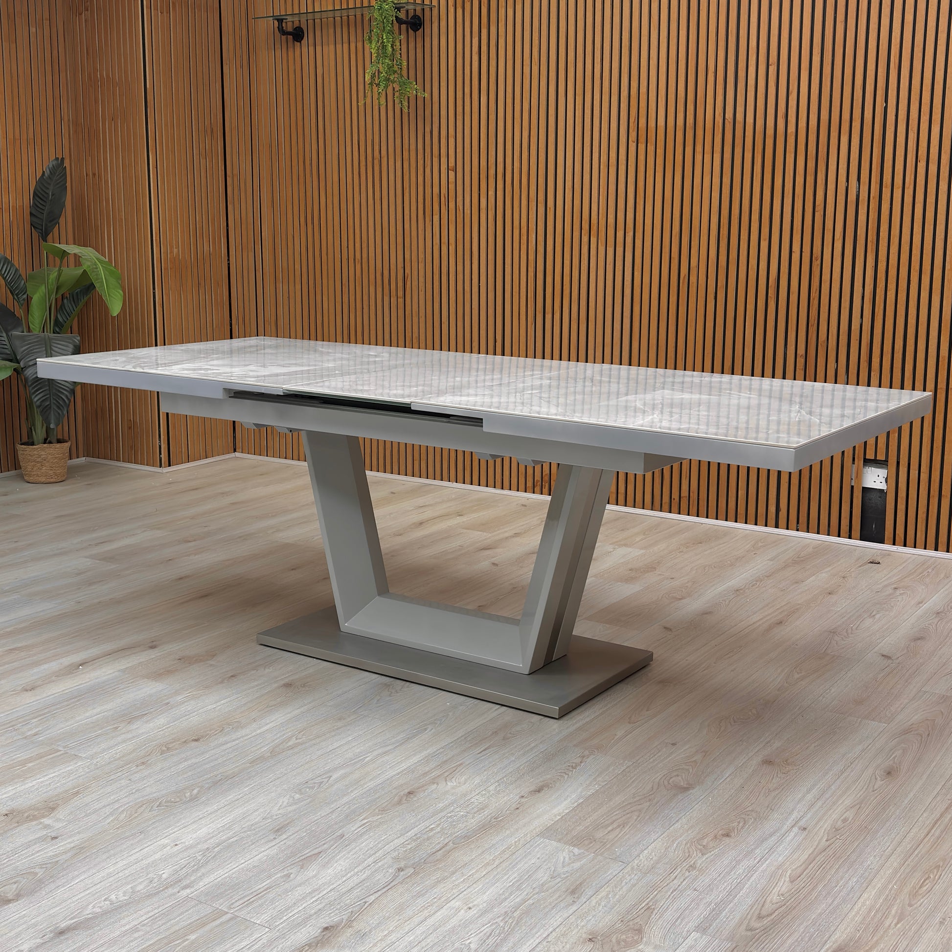 Lifestyle image of the 'Grigio' Extending Dining Table paired with contemporary chairs, showing its scale and elegance in a dining setting.