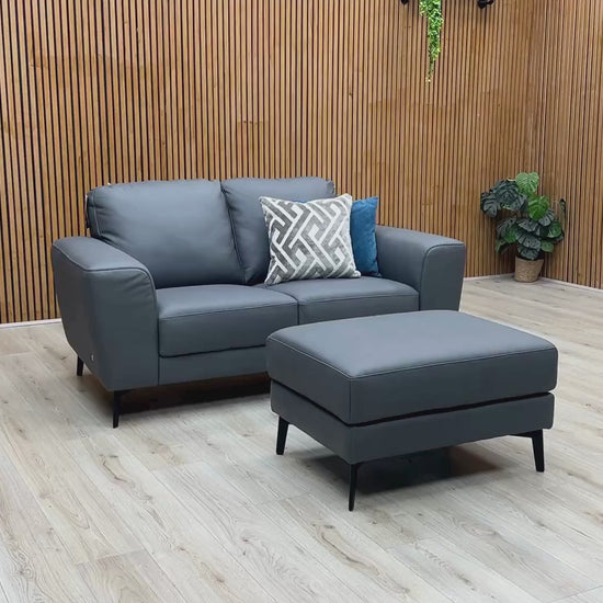 Video Of ‘Bocelli’ contemporary living room suite, showcasing a luxury 2-seater sofa and matching independent footstool beautifully upholstered in Tatto Grey 4370 premium leather.