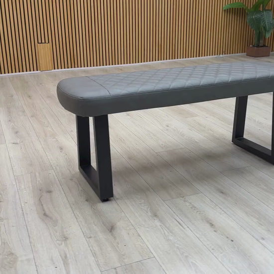 Video Of ‘Venus’ contemporary low dining bench, beautifully upholstered in a durable Grey faux leather with a clean, armless linear profile.