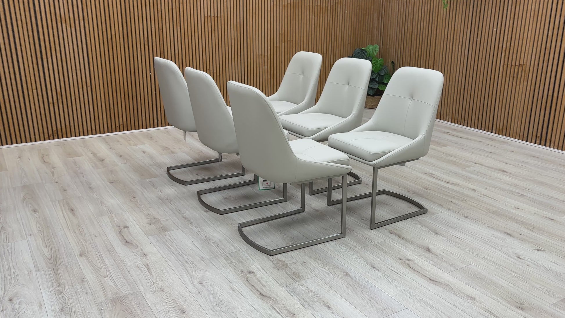 A video of Set of six modern gray chairs on a wooden deck with a wooden wall background