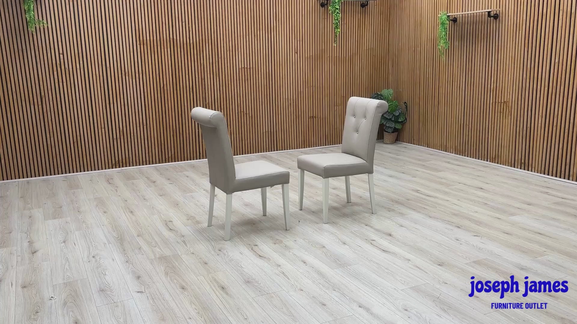 Video Of ‘Furnitureland Annecy’ dining chair set, showcasing a matching pair of two roll-back dining chairs with a soft grey painted finish and faux leather upholstery.