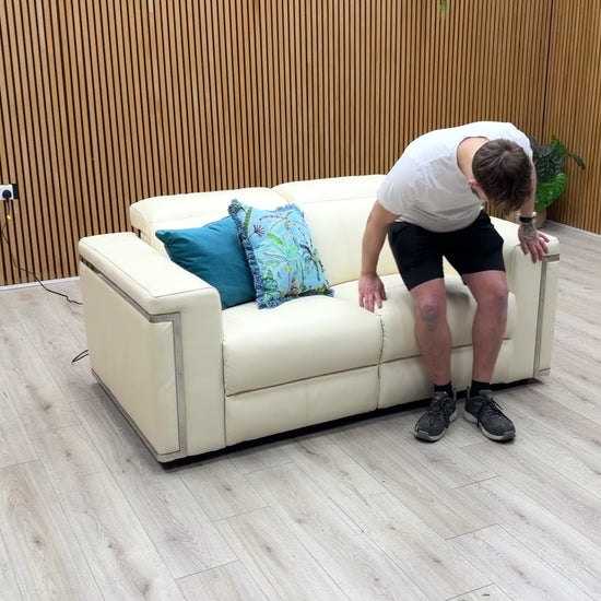 Product demonstration video showing the smooth power reclining mechanism and adjustable power headrests of the 'Cora' white leather sofa.