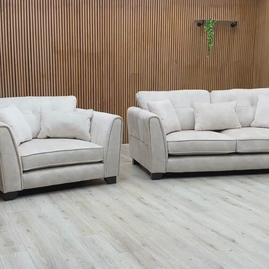 Video Of ‘Mariah’ contemporary living room furniture set, featuring a 3-seater classic back sofa and matching snuggler chair, beautifully upholstered in luxurious Dapple Ivory fabric with elegant brushed brass structural trim inserts.