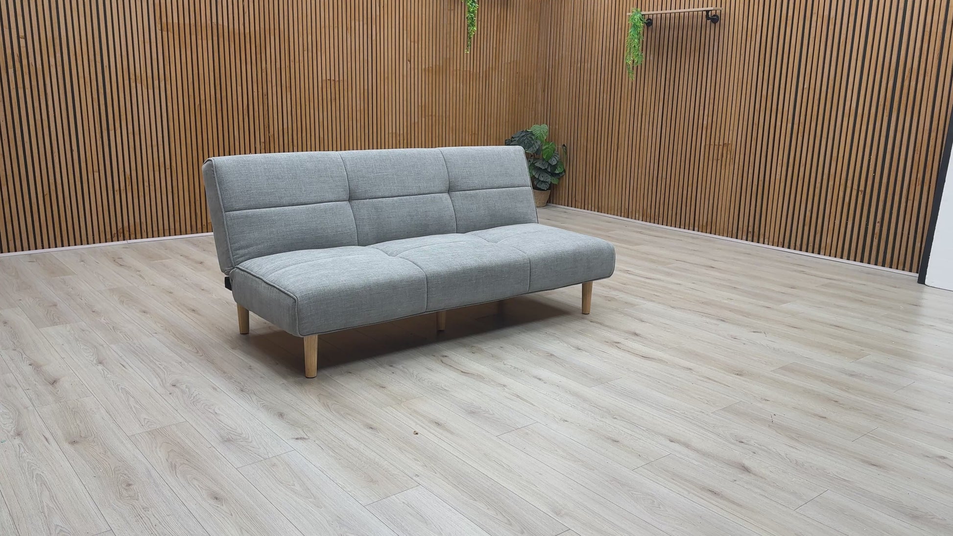 Product video tour of the ‘Miyagi’ Mist Grey Fabric Futon Sofa Bed, demonstrating the smooth transition from a stylish upright sofa to a flat, supportive guest bed.