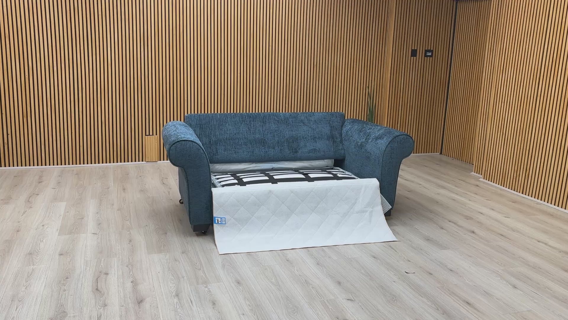 Product video tour of the ‘Hedingham’ Neptune Blue Bromley Chenille 2-Seater Sofa Bed, demonstrating the smooth transition from sofa to bed and the mattress quality.