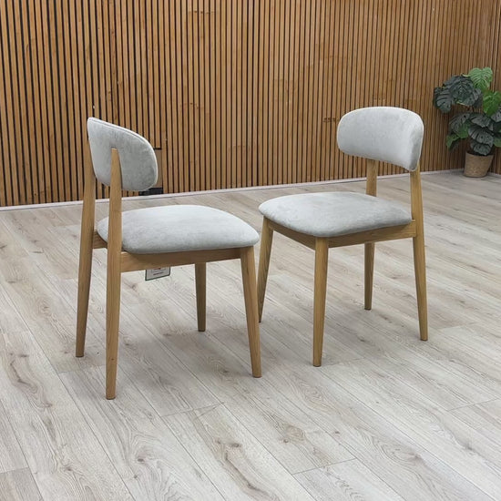 Product video tour of the ‘Stockholm’ Light Oak Wooden Dining Chairs, demonstrating the smooth tactile finish of the wood, structural stability, and weight-bearing strength.