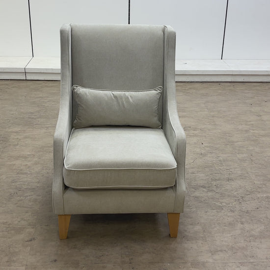 A video of a Gray armchair with a pillow on a white background