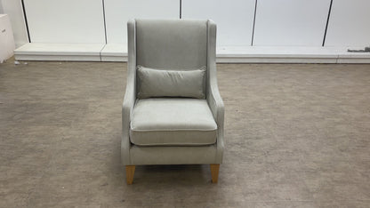 A video of a Gray armchair with a pillow on a white background