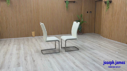 Video Of ‘Bianco’ contemporary dining chair set, showcasing a pair of sleek chairs beautifully upholstered in crisp White faux leather supported by minimalist chrome cantilever bases.