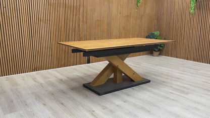 A video of a Wooden dining table with a black base against a wooden wall.