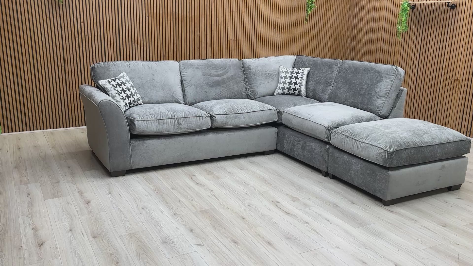 Product tour video of the Rosie Kingston Grey fabric corner sofa, demonstrating the cushion softness and the scale of the chaise arrangement.