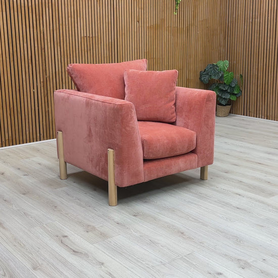 A video of an Orange armchair with cushions on a Wooden background