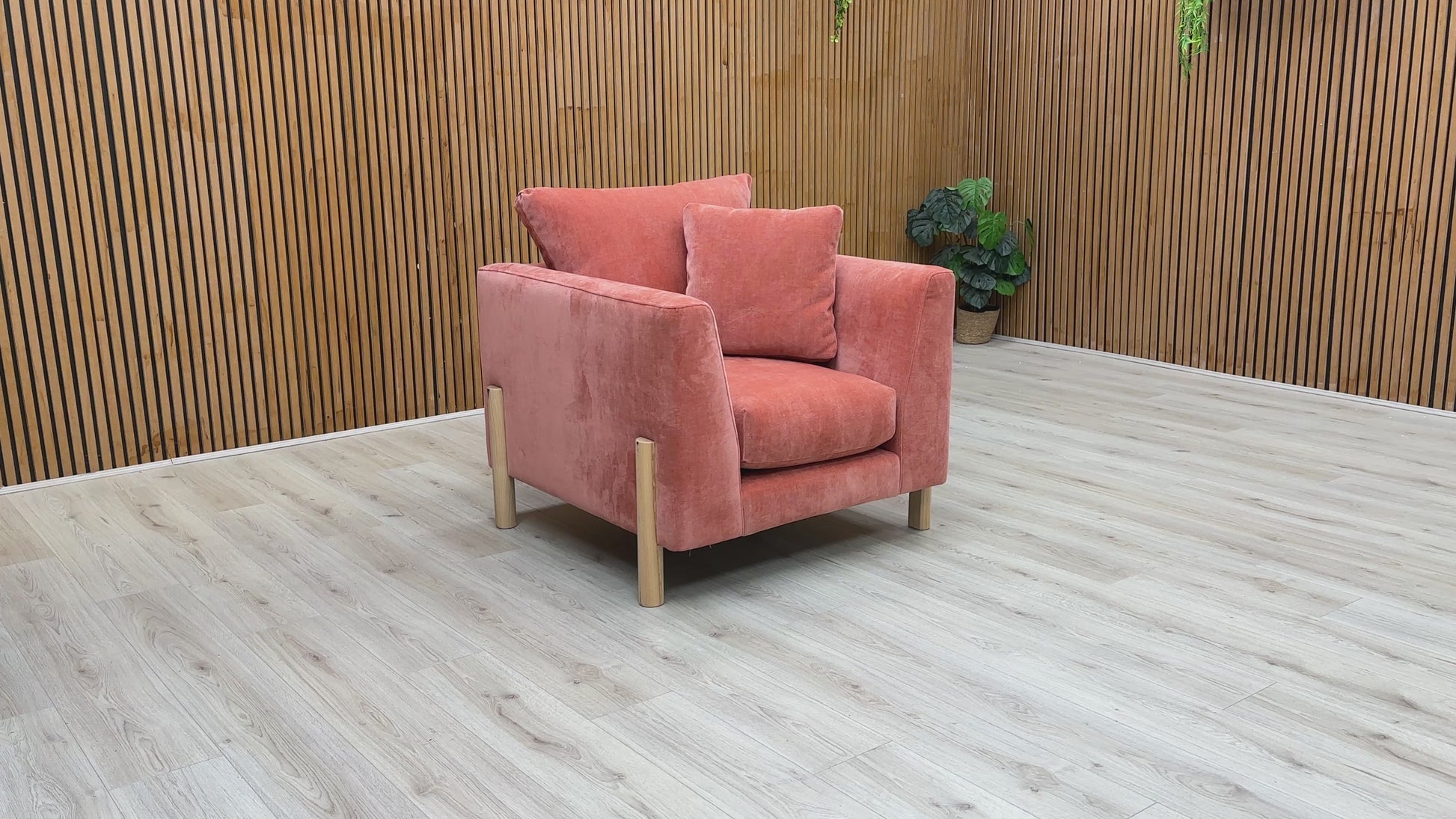 A video of an Orange armchair with cushions on a Wooden background