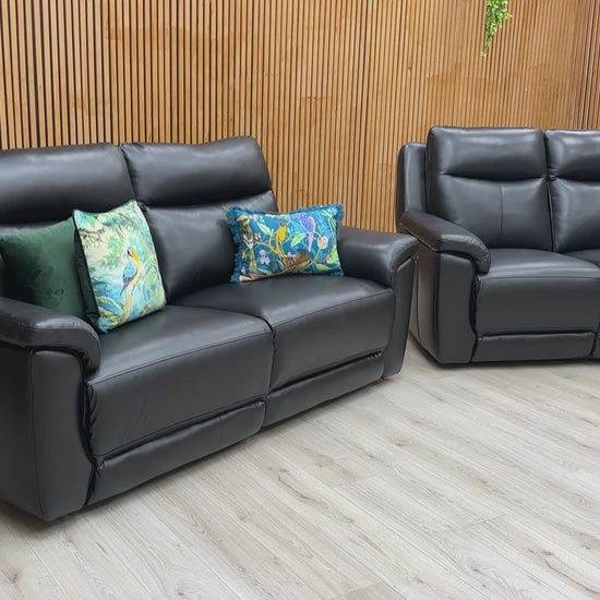 A video of Black leather sofa and recliner chair in a room with wooden walls and ceiling lights.