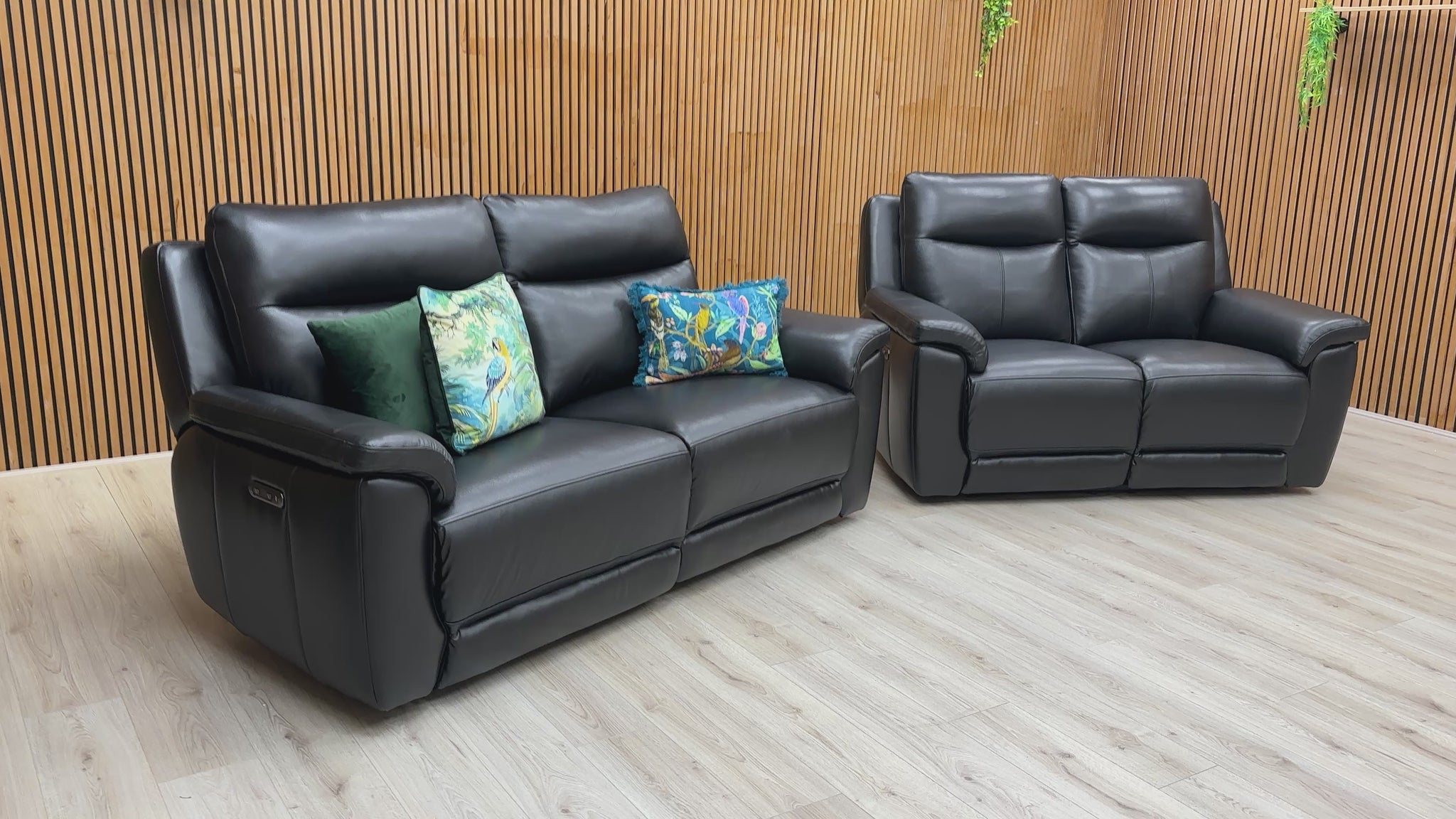 A video of Black leather sofa and recliner chair in a room with wooden walls and ceiling lights.