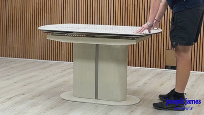 Video demonstration showing the unique swivel action transformation of the Avorio white ceramic dining table. Short clip highlights how a smooth 180-degree twist opens the hidden extension panels automatically.