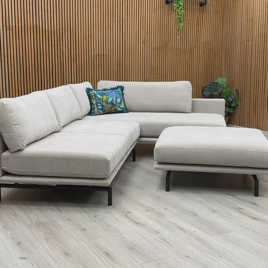 Product walk-around of the Brixton Taupe Fabric Corner Chaise, demonstrating the fabric texture, seat firmness, and footstool versatility.