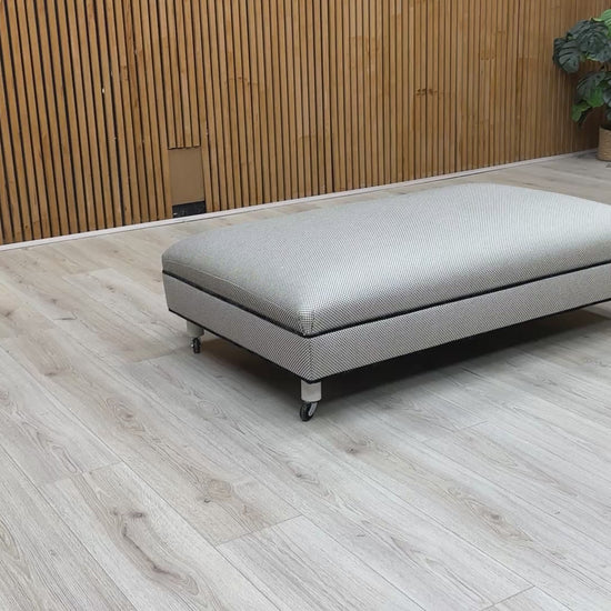 Video showcasing the scale and fabric texture of the Ambassador Allure Noir footstool in a room setting.
