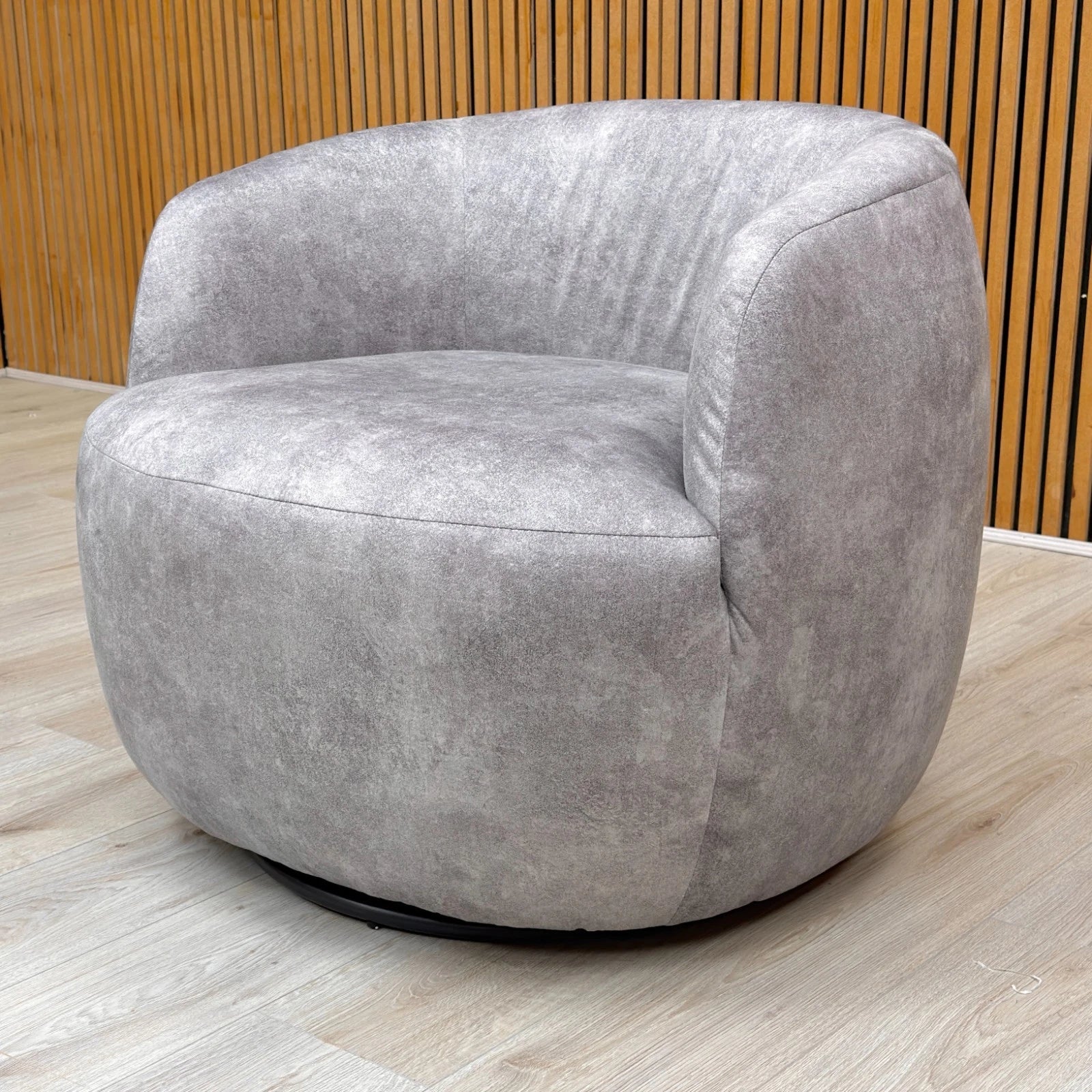 Lifestyle shot of the silver velvet swivel chair in a modern room setting, showcasing its elegant silhouette and shimmering upholstery.