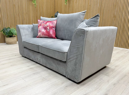Lifestyle view of the 2-seater velvet sofa in a living room setting, highlighting its elegant scatter back cushions.