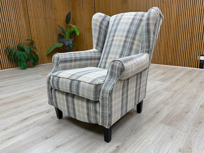 Side  of the 'Shirley' accent chair, showing the depth of the seat cushion, the curve of the scroll arm, and the shape of the wooden legs.