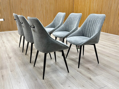 Lifestyle view of a Crete dark grey upholstered swivel dining chair featuring a modern curved silhouette and foam-padded seat.