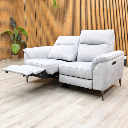 Lifestyle shot of the Dexter Smoke velvet sofa in a stylish living room setting, showcasing its compact size and comfortable, cushioned arms.