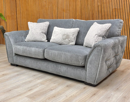 Lifestyle shot showing the elegant curved arms and button detailing of the 'Aphrodite' sofa.